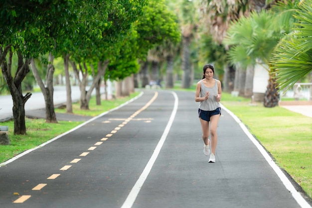 Hermosa mujer asiática corriendo en el parque Gente de Tailandia Los corredores corren entrenando para la competencia Estilo de vida de la mujer moderna