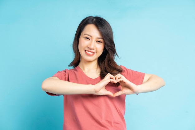 Hermosa mujer asiática dando forma a corazón con su mano