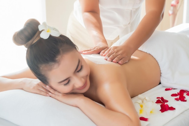 Una hermosa mujer asiática disfrutando de un masaje de exfoliante de sal en el spa de salud en Tailandia