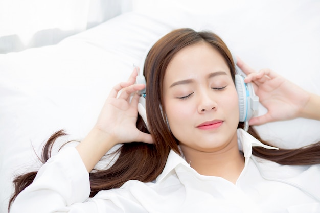 Hermosa mujer asiática disfrutar escuchar música con auriculares.