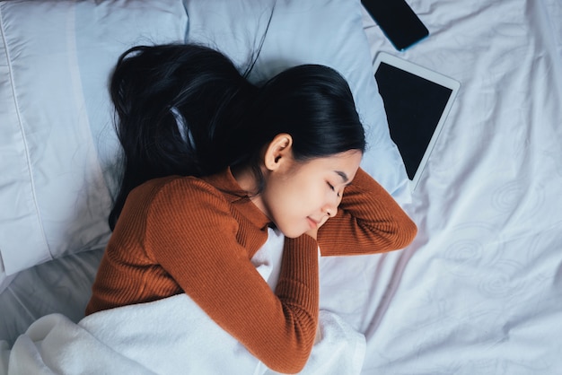 Hermosa mujer asiática durmiendo en la cama.