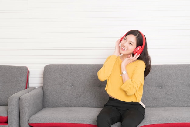 Hermosa mujer asiática escuchando música con auriculares