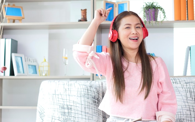 Hermosa mujer asiática escuchando música con auriculares