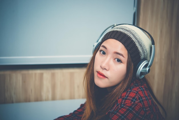 Hermosa mujer asiática escuchar música con auricularesestilo de vida de mujer modernaTailandia gente como canciónconcepto de niña feliz