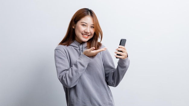 Hermosa mujer asiática gesticulando para la edición de anuncios en el concepto de retrato de fondo aislado utilizado para publicidad y señalización aislado sobre el espacio de copia de fondo blanco