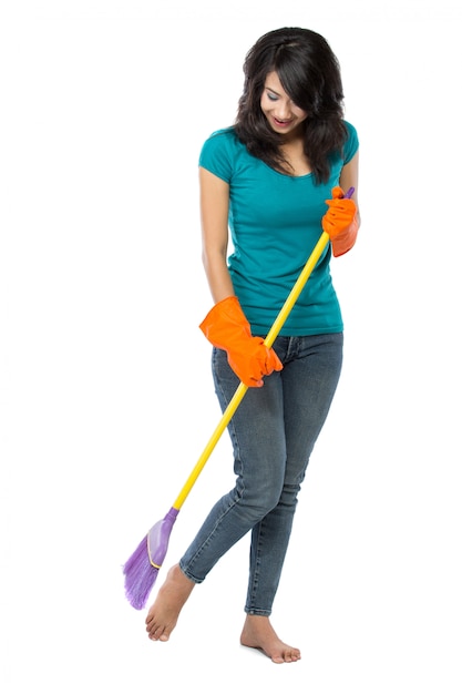 Foto hermosa mujer asiática con guantes, barriendo el piso con una escoba