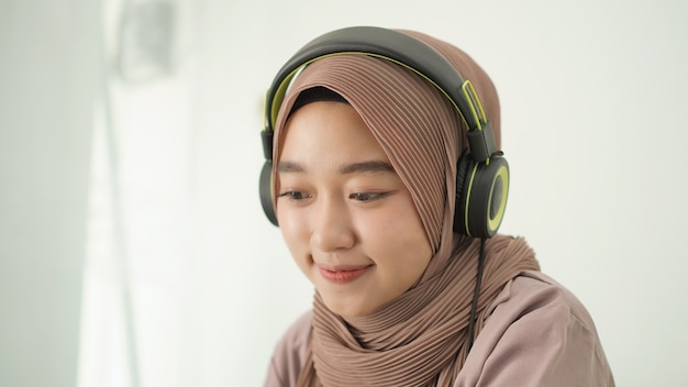 Hermosa mujer asiática en hijab escuchando atentamente