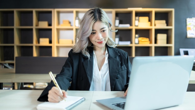 Hermosa mujer asiática independiente que trabaja en línea en la oficina en casa Felicidad joven mujer asiática que trabaja en una computadora portátil portátil Pequeñas y medianas empresas negocios autónomos en línea PYME