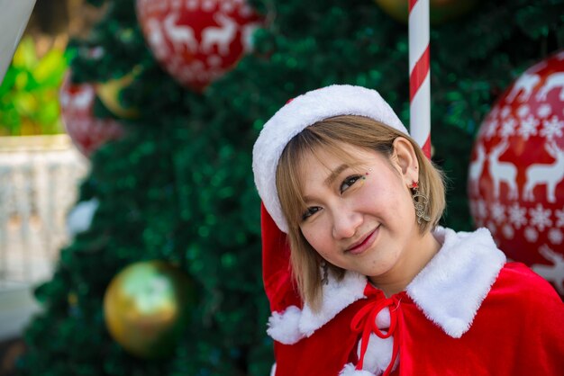 Hermosa mujer asiática joven en ropa de Santa Claus al aire libre