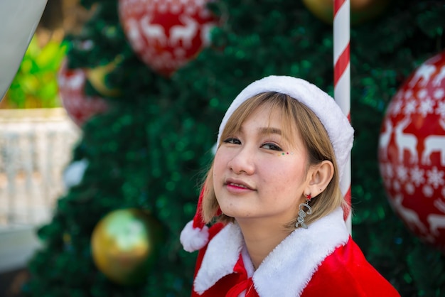 Hermosa mujer asiática joven en ropa de Santa Claus al aire libre