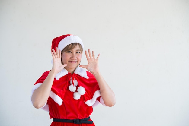 Hermosa mujer asiática joven en ropa de Santa Claus sobre fondo blancoGente de TailandiaEnvió felicidad para los niñosFeliz NavidadBienvenido al inviernoConcepto de mujer feliz