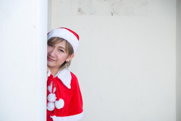 Hermosa mujer asiática joven en ropa de Santa Claus sobre fondo blancoGente de TailandiaEnvió felicidad para los niñosFeliz NavidadBienvenido al inviernoConcepto de mujer feliz