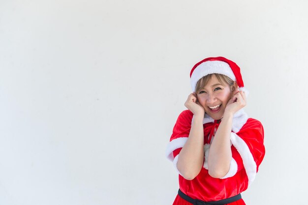 Hermosa mujer asiática joven en ropa de Santa Claus sobre fondo blancoGente de TailandiaEnvió felicidad para los niñosFeliz NavidadBienvenido al inviernoConcepto de mujer feliz