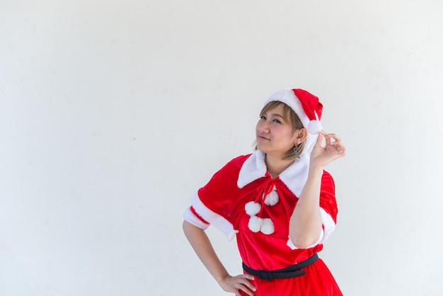 Hermosa mujer asiática joven en ropa de Santa Claus sobre fondo blancoGente de TailandiaEnvió felicidad para los niñosFeliz NavidadBienvenido al inviernoConcepto de mujer feliz