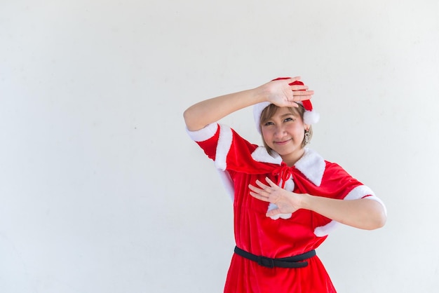 Hermosa mujer asiática joven en ropa de Santa Claus sobre fondo blancoGente de TailandiaEnvió felicidad para los niñosFeliz NavidadBienvenido al inviernoConcepto de mujer feliz