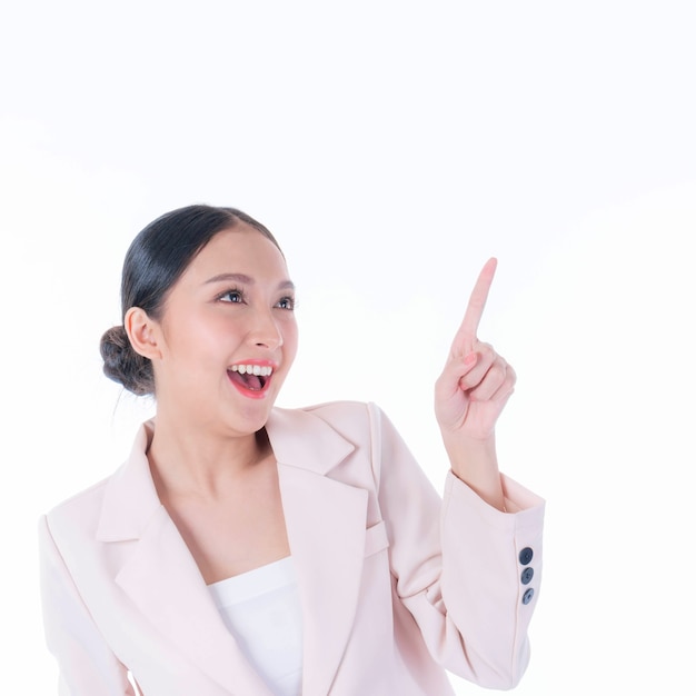 Hermosa mujer asiática linda sonriendo y señalando con el dedo al espacio vacío de la copia, espacio en blanco para publicidad aislado sobre fondo blanco.