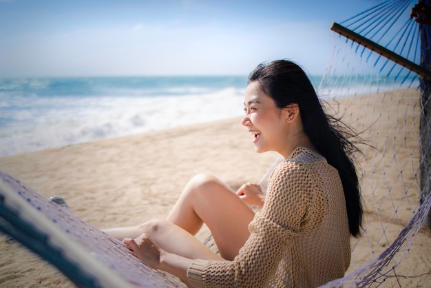 Hermosa mujer asiática relajarse en la playa