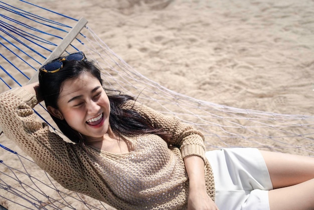 Hermosa mujer asiática relajarse en la playa