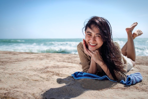 Hermosa mujer asiática relajarse en la playa