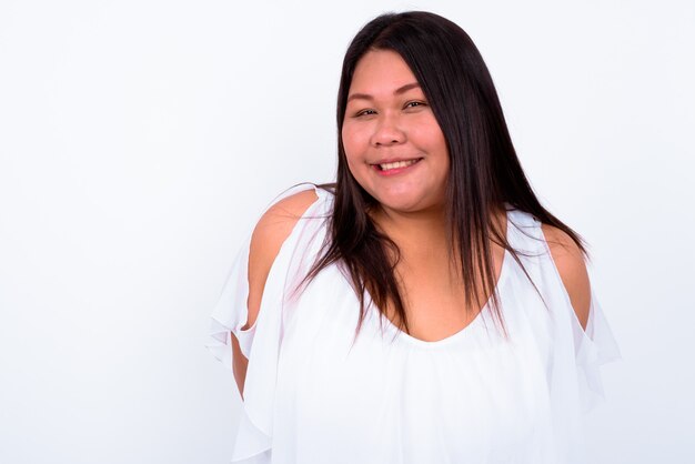 Foto hermosa mujer asiática con sobrepeso contra la pared blanca