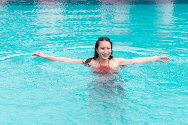 Hermosa mujer asiática sonriendo en una piscina