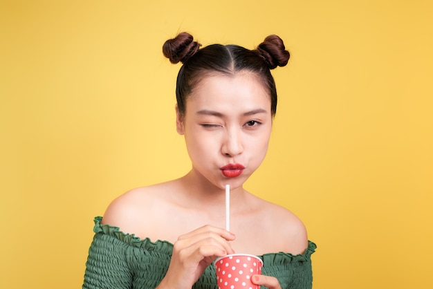 Hermosa mujer asiática sonriente loca chica con labios rojos bebiendo cola con paja