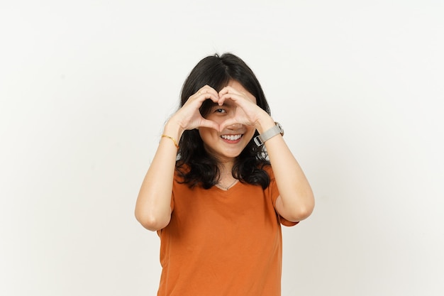 Hermosa mujer asiática vistiendo camiseta de color naranja hacer y mostrando el signo de la mano del corazón del amor