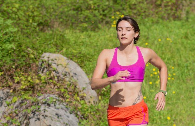 Hermosa mujer atlética corriendo en campo