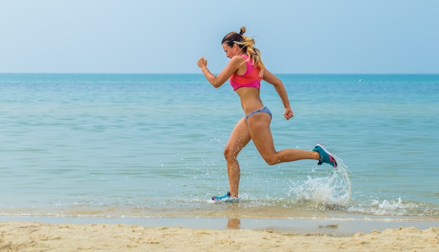 hermosa mujer atlética corriendo en la playa, estilo de vida saludable