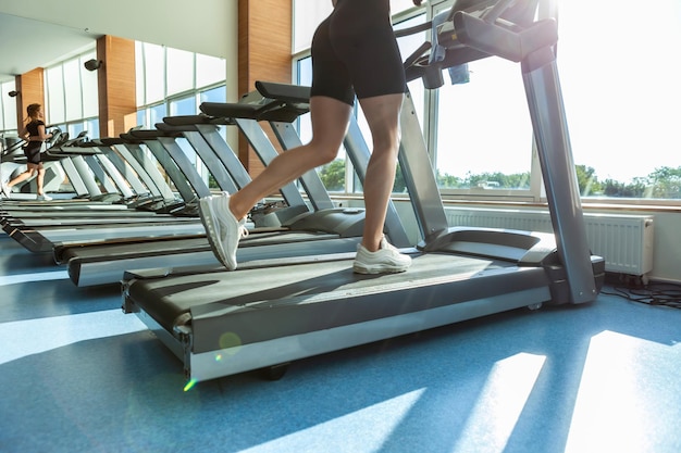 Hermosa mujer atlética sexy corriendo en una cinta en el gimnasio