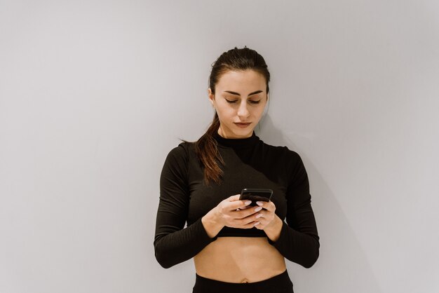 Hermosa mujer atlética con un teléfono móvil