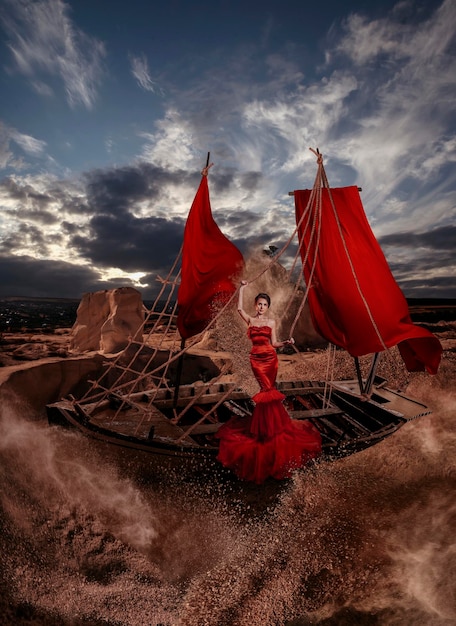 Hermosa mujer con barco en el desierto