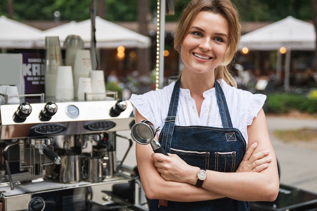 Hermosa mujer barista durante el trabajo en su cafetería de la calle móvil