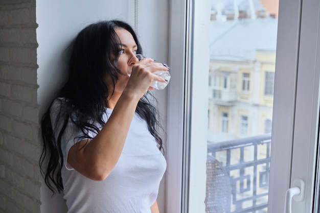 Hermosa mujer bebiendo leche, yogurt de vidrio