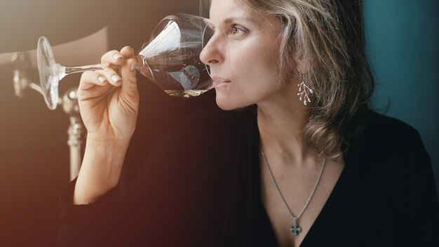 Hermosa mujer bebiendo vino en el restaurante