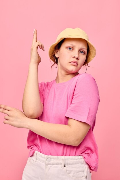 Hermosa mujer en beige panamá camiseta rosa mano gestos modelo de estudio