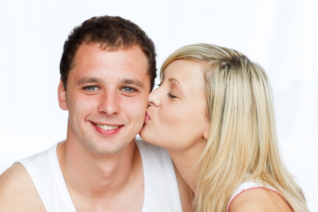 Hermosa mujer besando a un hombre sonriente