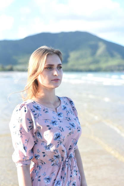 Hermosa mujer bielorrusa caminando por la playa contra el cielo dramático y romántico