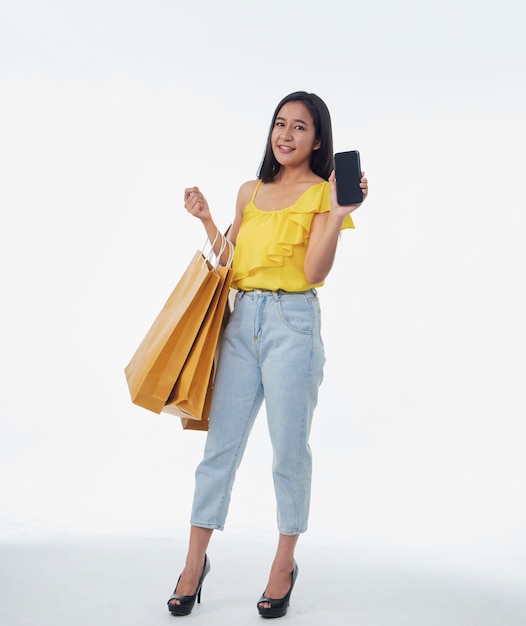 Hermosa mujer con bolsas de compras y teléfono inteligente