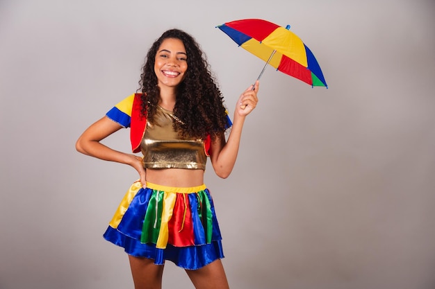 Hermosa mujer brasileña negra con traje de frevo y carnaval de paraguas