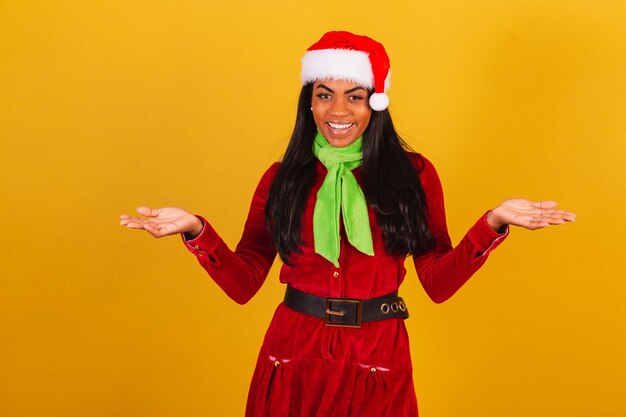 Foto hermosa mujer brasileña negra vestida con ropa navideña santa claus con los brazos abiertos bienvenidos
