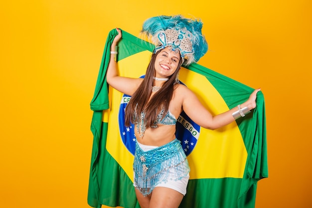 Hermosa mujer brasileña con ropa de carnaval azul corona de plumas reina del carnaval con bandera de brasil