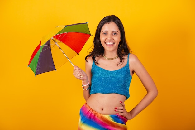 Hermosa mujer brasileña en ropa de carnaval con paraguas colorido