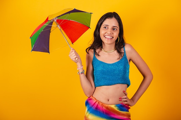 Hermosa mujer brasileña en ropa de carnaval con paraguas colorido