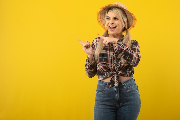 Hermosa mujer brasileña con ropa de festa junina sobre fondo amarillo