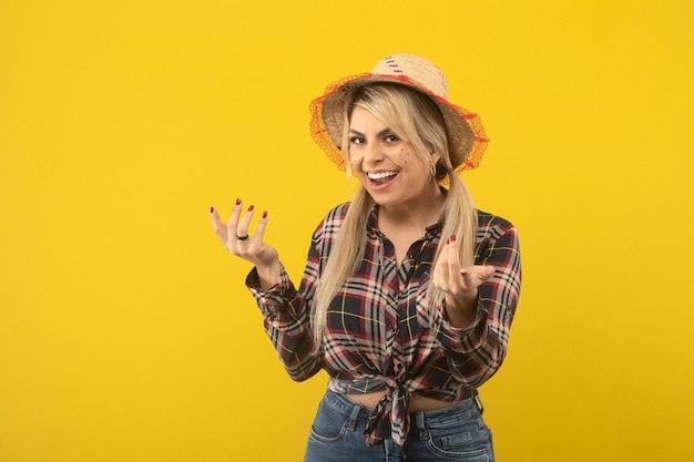 Hermosa mujer brasileña con ropa de festa junina sobre fondo amarillo