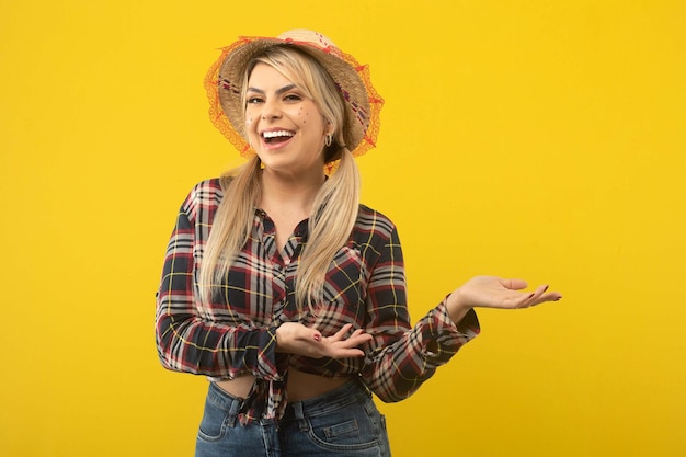 Foto hermosa mujer brasileña con ropa de festa junina sobre fondo amarillo