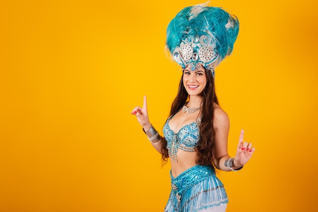 Hermosa mujer brasileña con ropa de reina del carnaval de la escuela de samba Corona de plumas bailando