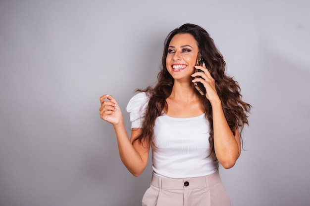 Hermosa mujer brasileña sosteniendo una llamada de voz de teléfono inteligente hablando