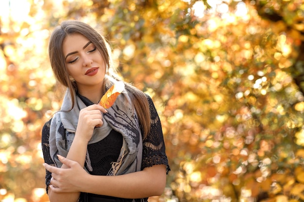 Hermosa mujer con bufanda gris en otoño